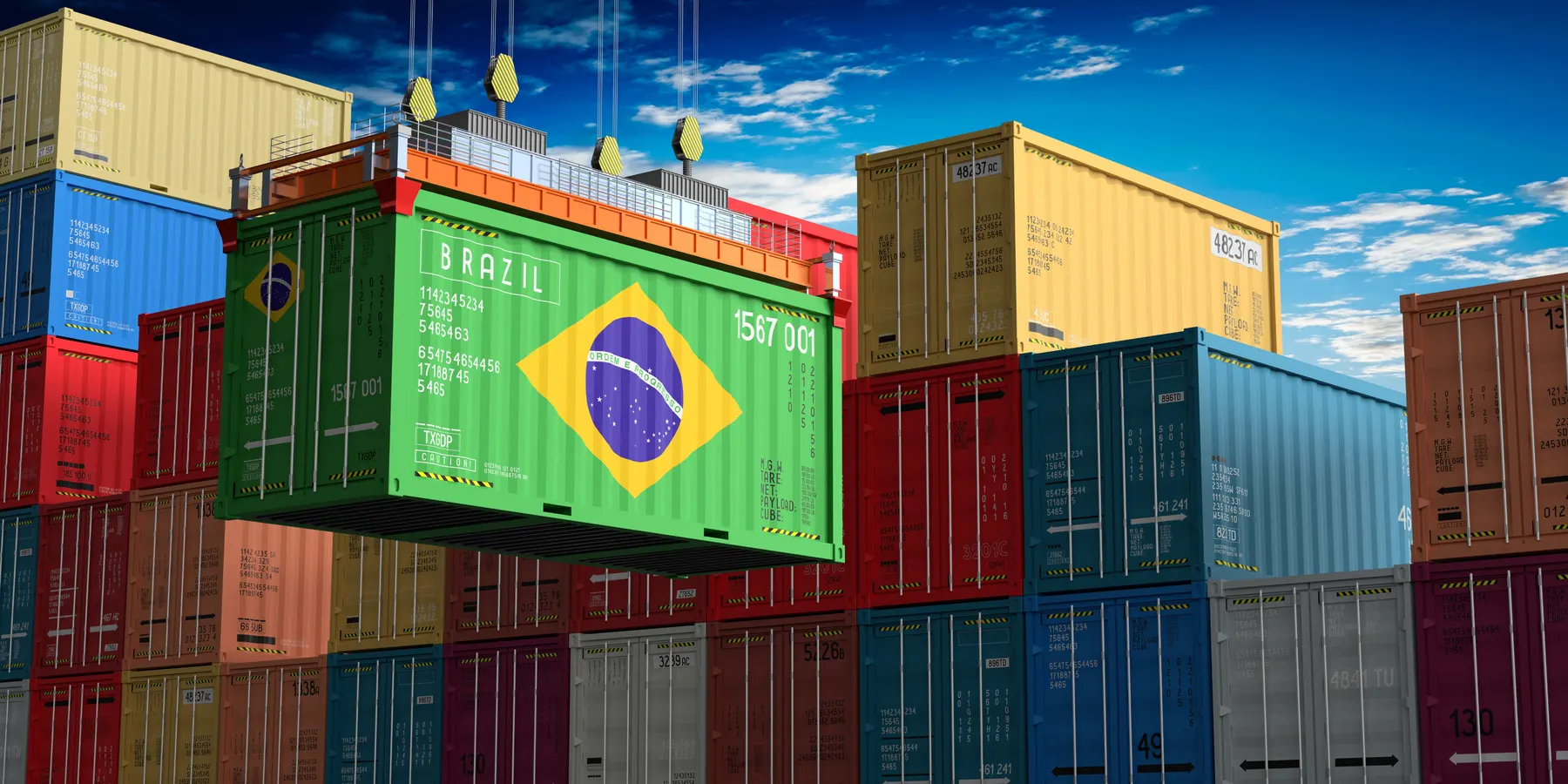Contêineres com a bandeira do Brasil em pátio logístico